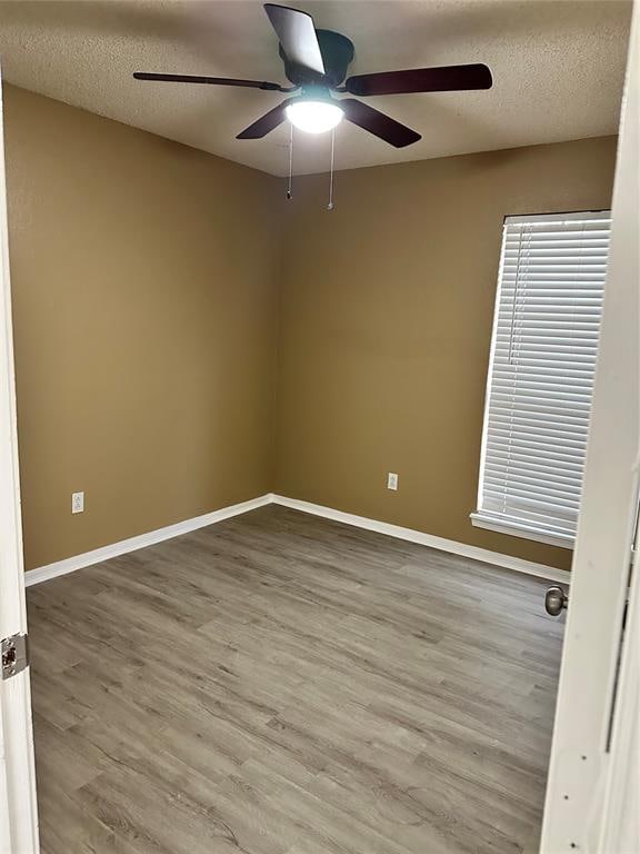 spare room with wood-type flooring, a textured ceiling, and ceiling fan