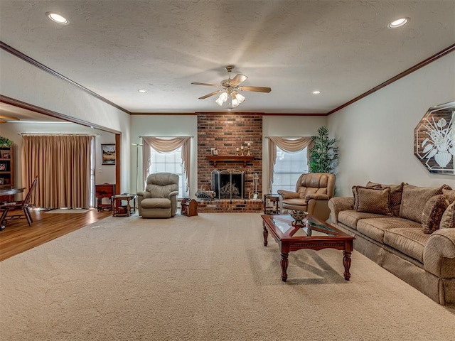 living room featuring ceiling fan, ornamental molding, a healthy amount of sunlight, and hardwood / wood-style flooring