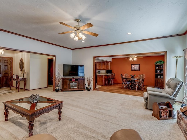 living room with light carpet, ceiling fan, and ornamental molding