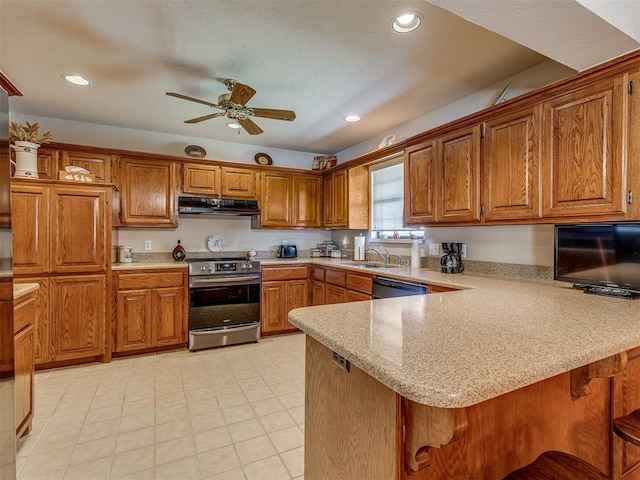 kitchen with sink, ceiling fan, appliances with stainless steel finishes, a kitchen bar, and kitchen peninsula