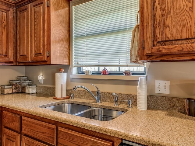 kitchen featuring light stone countertops and sink