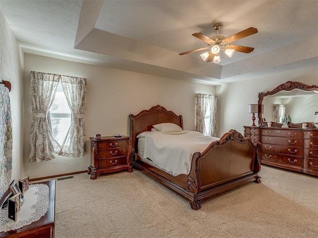 bedroom featuring a tray ceiling, ceiling fan, and carpet floors