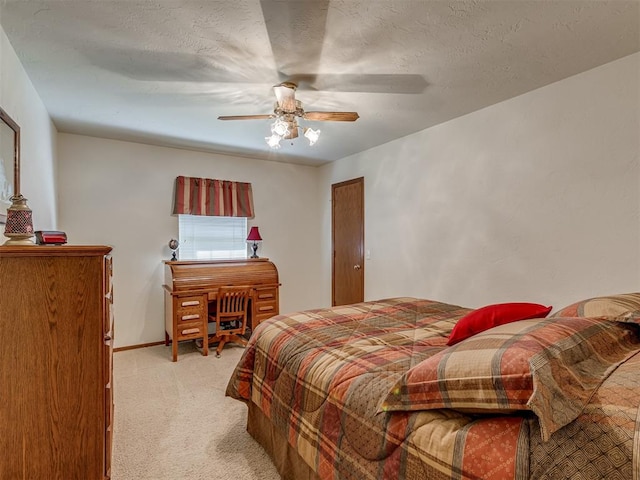 carpeted bedroom featuring ceiling fan and a textured ceiling