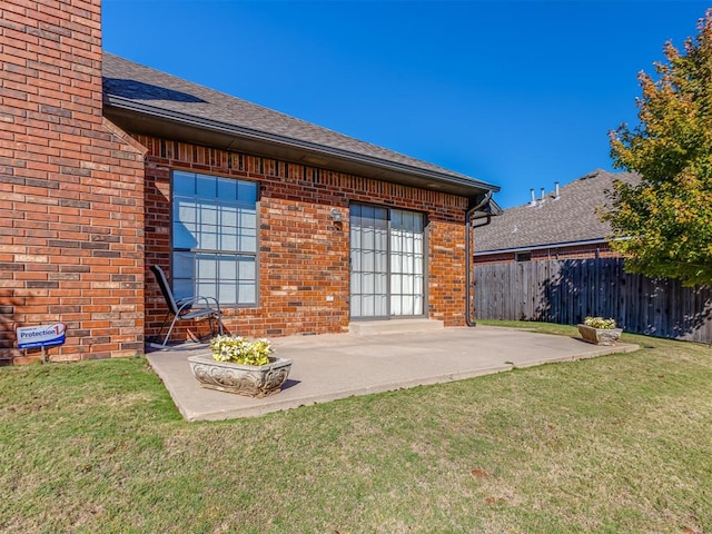 back of house with a patio area and a yard