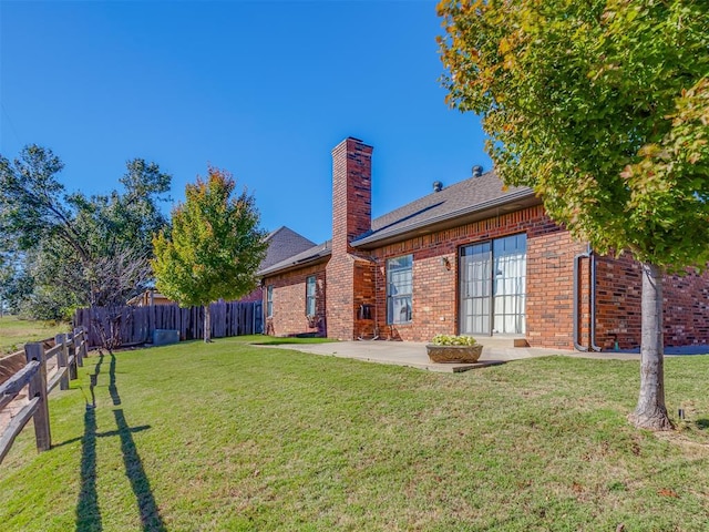 back of property featuring a patio area and a yard