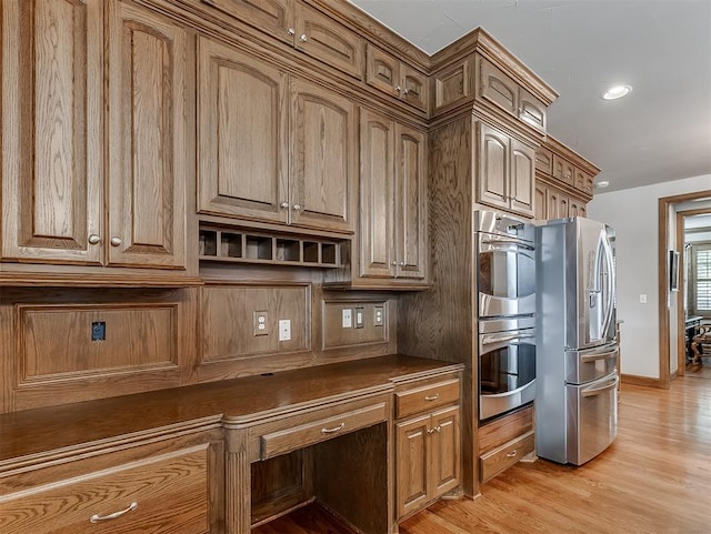 kitchen featuring stainless steel appliances and light hardwood / wood-style flooring