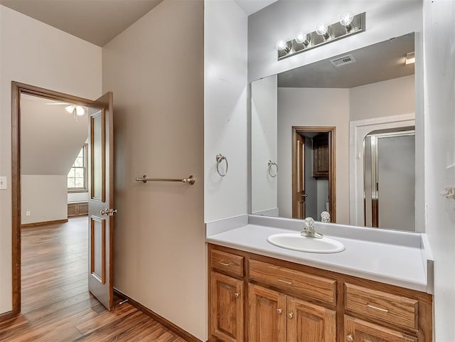 bathroom with vanity, a shower with shower door, and hardwood / wood-style flooring