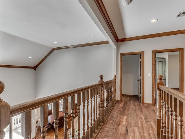 hall with ornamental molding, light wood-type flooring, and lofted ceiling