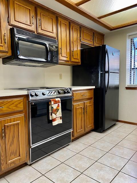 kitchen featuring light tile patterned floors and black appliances