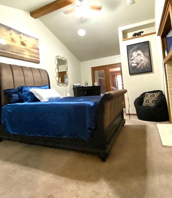 carpeted bedroom featuring a fireplace, lofted ceiling with beams, and ceiling fan