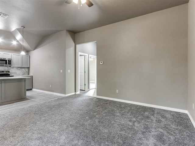 unfurnished living room featuring light carpet, ceiling fan, and lofted ceiling