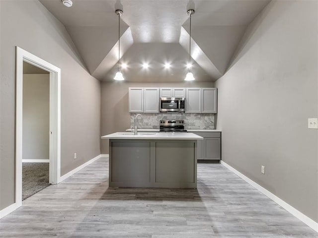 kitchen with gray cabinetry, sink, hanging light fixtures, decorative backsplash, and appliances with stainless steel finishes