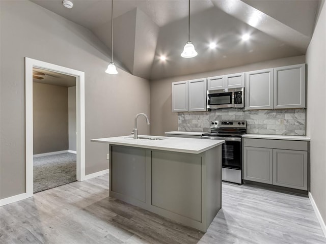 kitchen featuring gray cabinetry, sink, stainless steel appliances, pendant lighting, and lofted ceiling