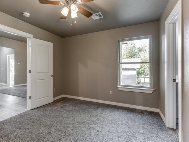 carpeted spare room with ceiling fan