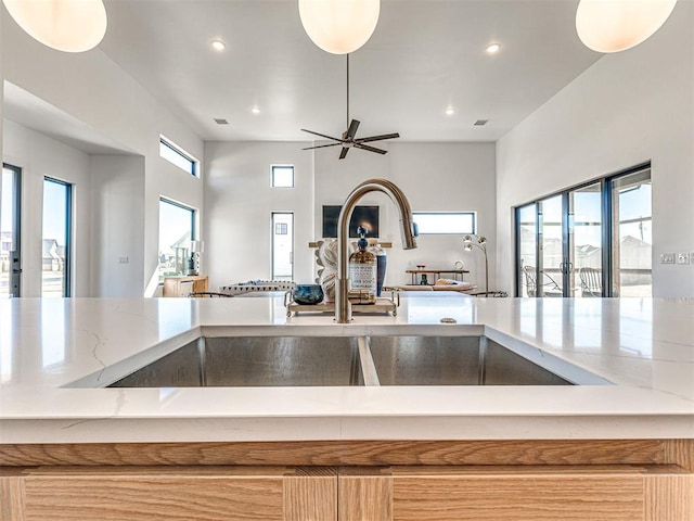 kitchen featuring a fireplace, ceiling fan, and sink