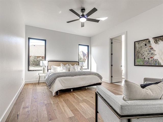 bedroom with ceiling fan, light wood-type flooring, and multiple windows