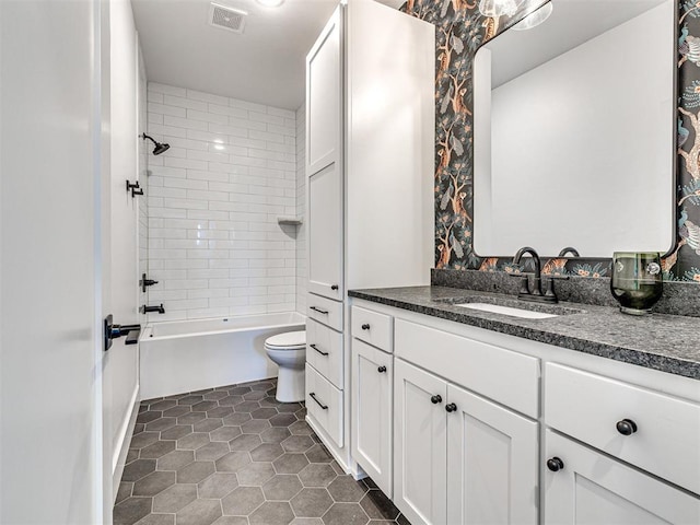 full bathroom with tile patterned flooring, vanity, toilet, and tiled shower / bath