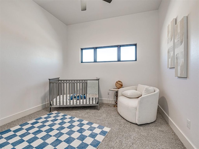 bedroom with ceiling fan, a crib, and carpet floors