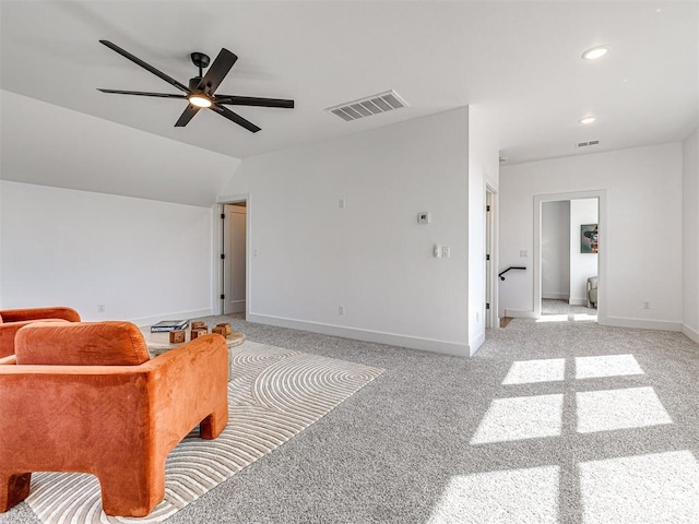 living area with ceiling fan, light carpet, and vaulted ceiling