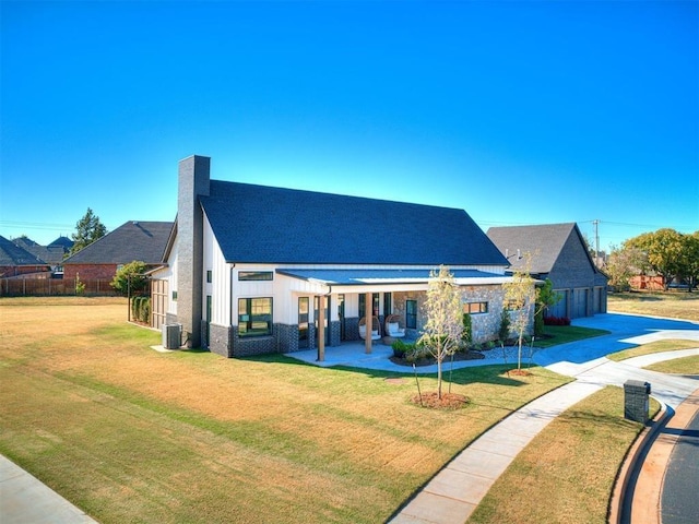 view of front facade with central AC unit and a front lawn