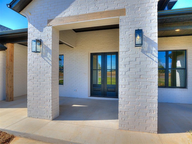 view of exterior entry featuring french doors and a patio