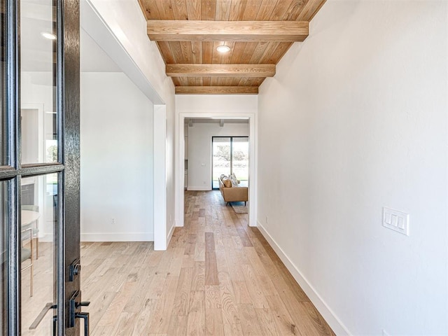 hallway with beam ceiling, wood ceiling, and light wood-type flooring