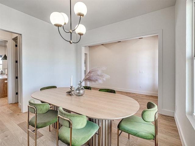 dining area featuring a notable chandelier and light wood-type flooring