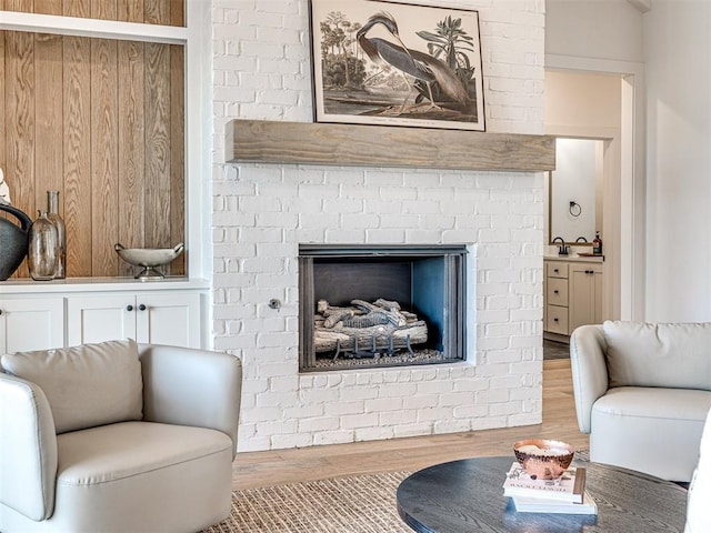 living room with hardwood / wood-style floors and a brick fireplace