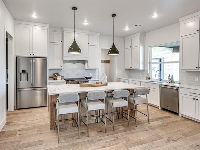 kitchen featuring white cabinets, a kitchen island, and appliances with stainless steel finishes