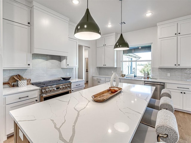 kitchen with a spacious island, white cabinets, and stainless steel appliances