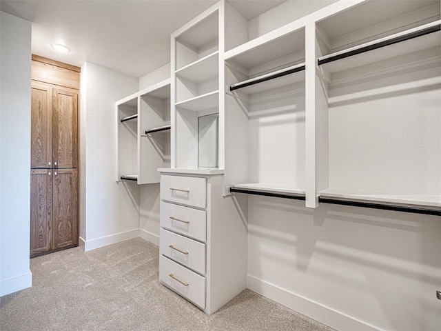 walk in closet featuring light colored carpet