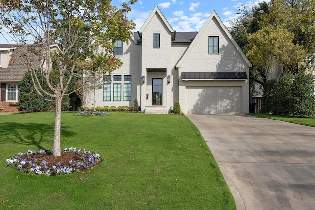 view of front of home with a garage and a front lawn