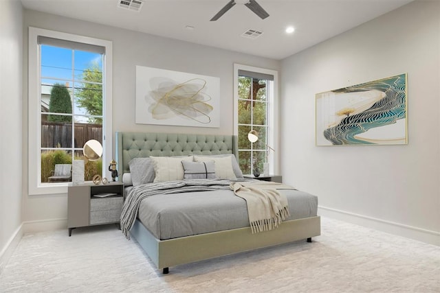 carpeted bedroom with ceiling fan and multiple windows