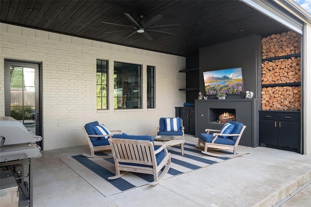 view of patio / terrace with an outdoor living space with a fireplace and ceiling fan