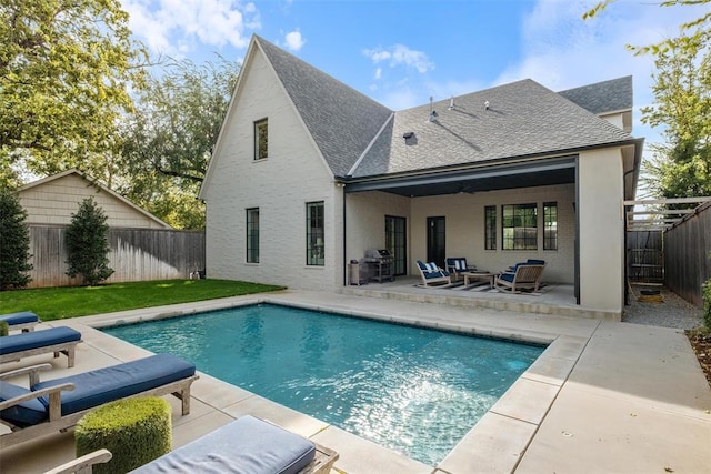 back of house featuring outdoor lounge area, ceiling fan, a fenced in pool, and a patio