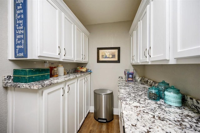 clothes washing area with baseboards and dark wood-type flooring