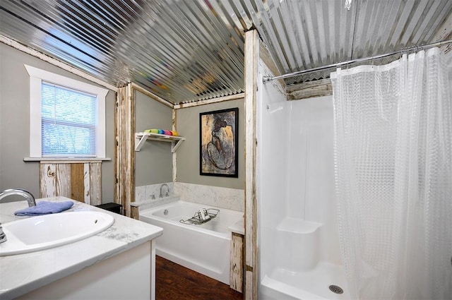 bathroom with a garden tub, a stall shower, and vanity