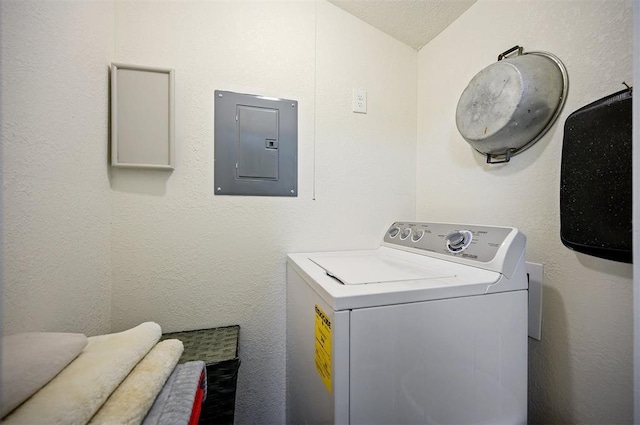 clothes washing area with electric panel, a textured wall, laundry area, and washer / dryer