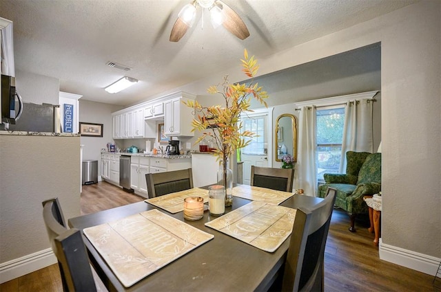 dining area featuring a ceiling fan, dark wood-style flooring, baseboards, and visible vents