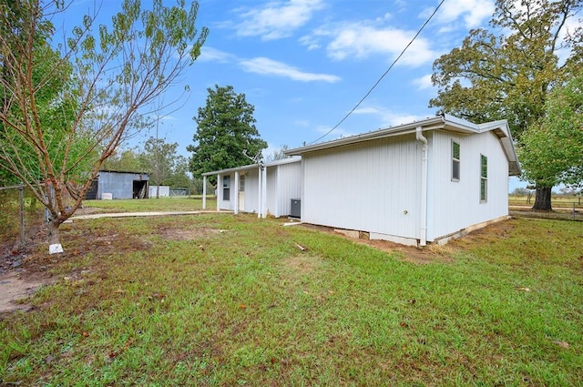 rear view of house featuring fence and a lawn