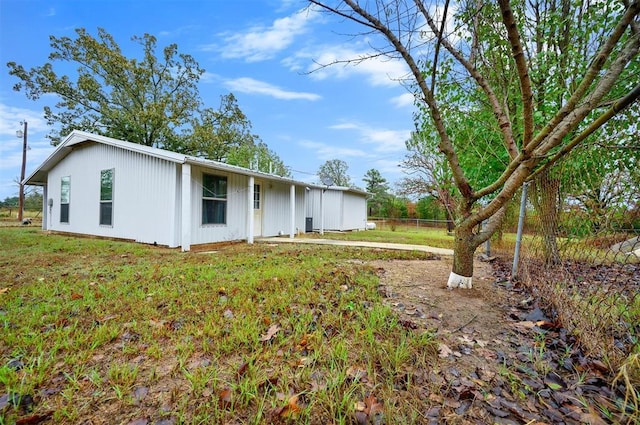 back of property featuring fence and a yard