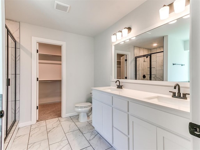 bathroom featuring vanity, a shower with shower door, and toilet