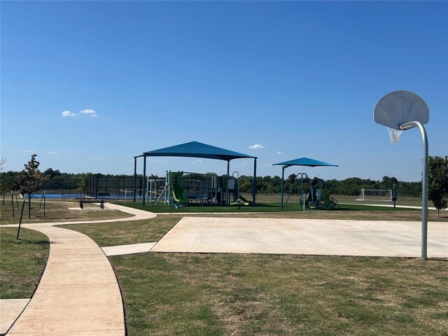 surrounding community featuring basketball court, a playground, and a lawn