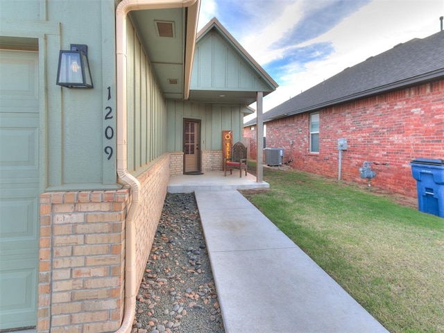 property entrance featuring a yard and central AC