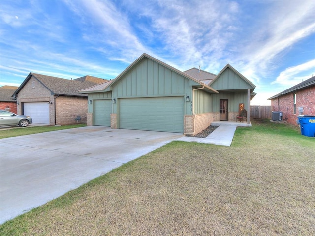 view of front of home featuring a garage, central air condition unit, and a front lawn