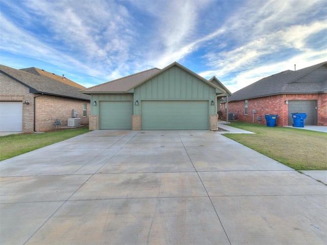 view of front of property featuring a front lawn, central AC unit, and a garage