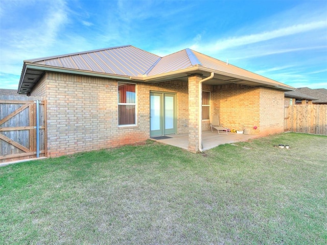 rear view of house featuring a patio area and a yard