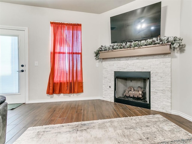 unfurnished living room featuring a fireplace and dark wood-type flooring