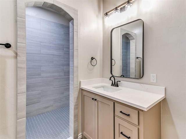 bathroom featuring vanity and tiled shower