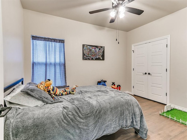 bedroom featuring ceiling fan, a closet, and wood-type flooring